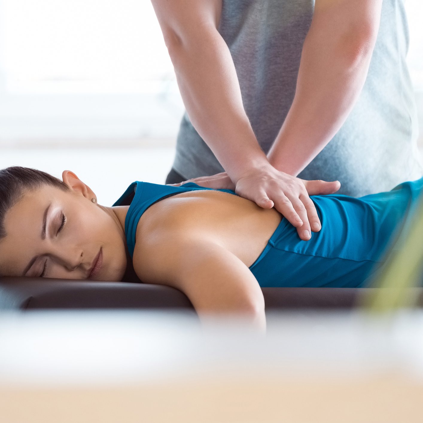 Physiotherapist massaging young woman